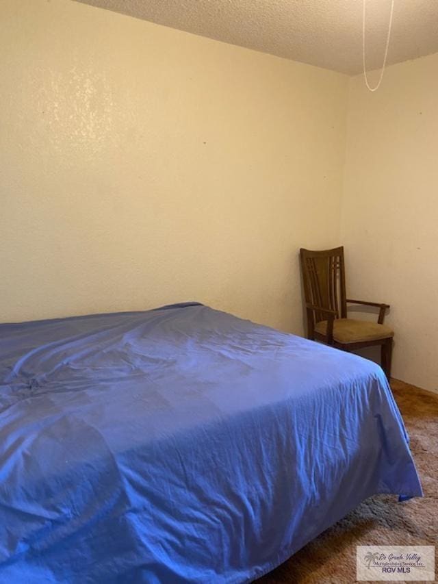 carpeted bedroom with a textured ceiling