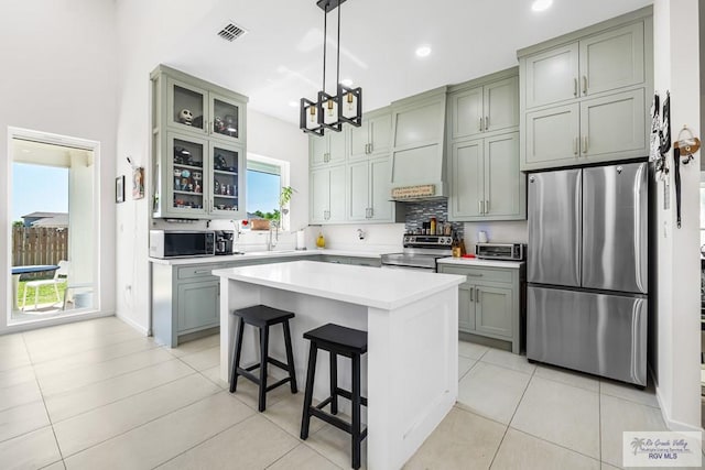 1749 Vincent St, Donna, TX 78537 - kitchen with glass insert cabinets, stainless steel appliances, light countertops, a kitchen bar, and visible vents