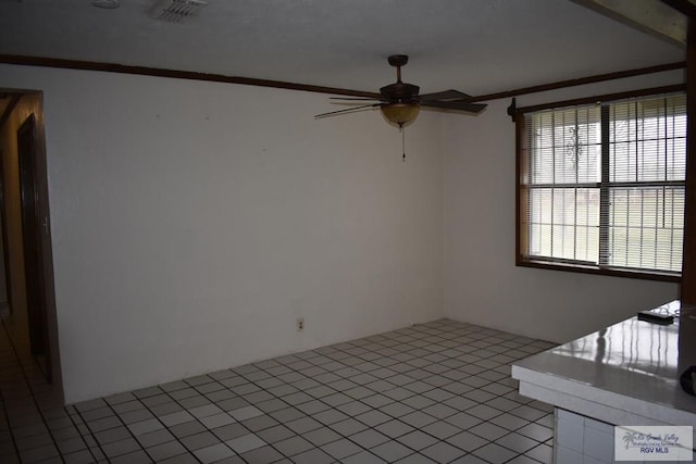 empty room featuring ornamental molding and ceiling fan