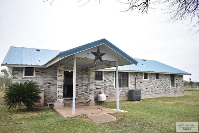 back of property featuring a lawn and central air condition unit