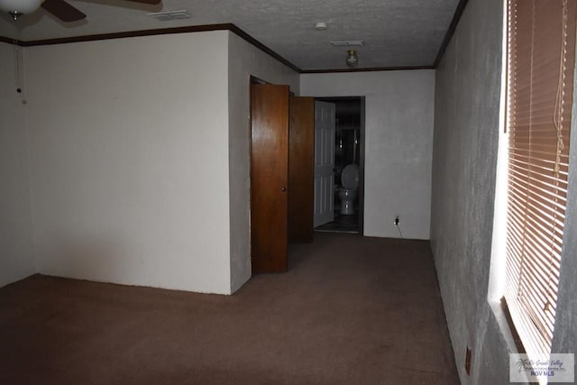 hall with ornamental molding, carpet floors, and a textured ceiling