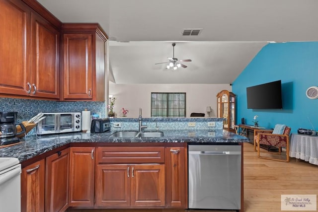 kitchen featuring visible vents, a ceiling fan, a sink, a peninsula, and dishwasher