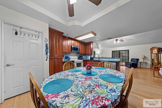 dining room featuring visible vents, light wood-style flooring, a toaster, lofted ceiling, and ceiling fan