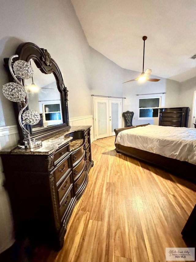 bedroom with ceiling fan, french doors, vaulted ceiling, and light wood-type flooring