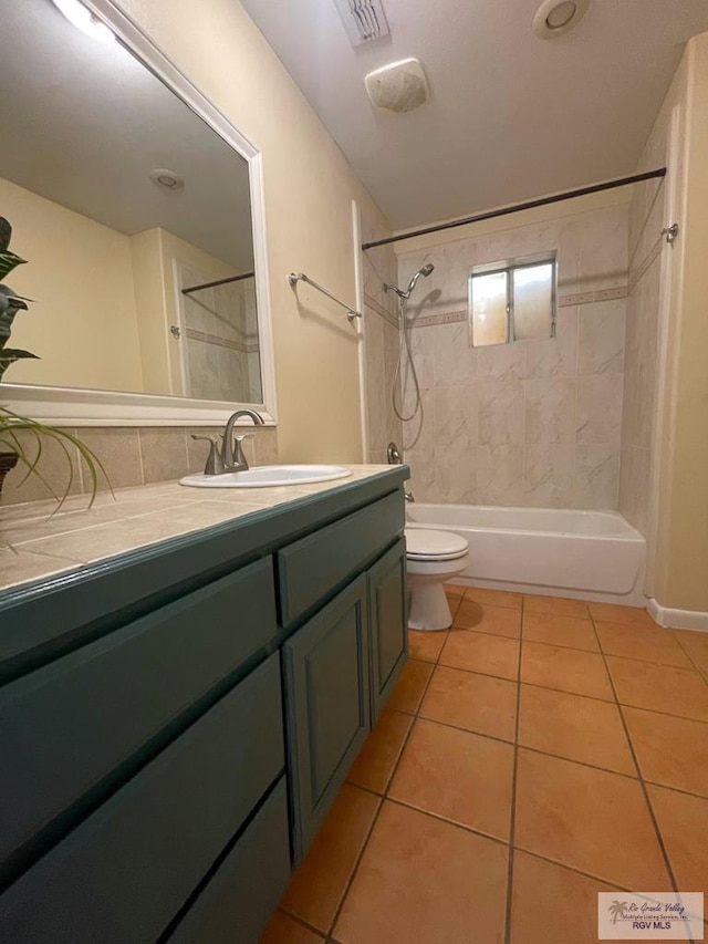 full bathroom with tile patterned flooring, vanity, toilet, and tiled shower / bath