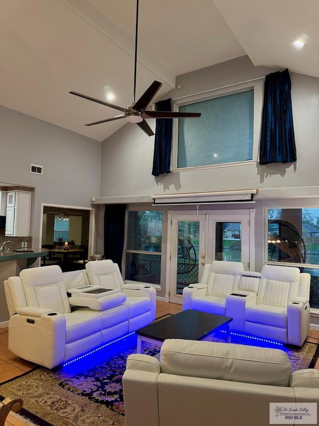 tiled living room with ceiling fan, beam ceiling, and high vaulted ceiling