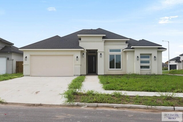 prairie-style home featuring a front yard and a garage