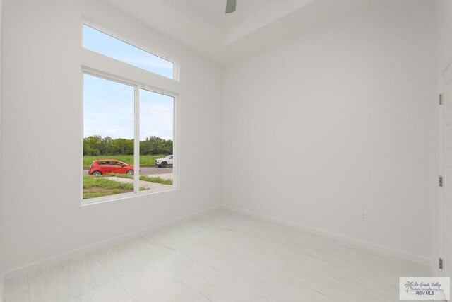 spare room with ceiling fan and plenty of natural light