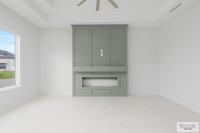 empty room featuring a tray ceiling and ceiling fan