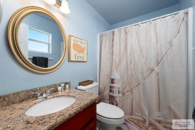 bathroom featuring a shower with curtain, vanity, and toilet