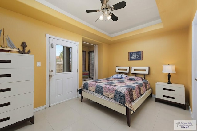 bedroom with a tray ceiling, ceiling fan, and tile patterned flooring