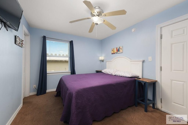 bedroom featuring ceiling fan and dark carpet