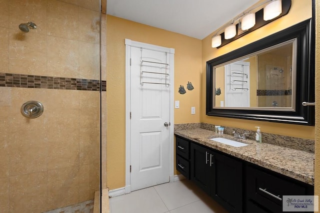 bathroom with tile patterned flooring, vanity, and tiled shower