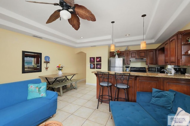 living room featuring ceiling fan, a raised ceiling, light tile patterned floors, and sink