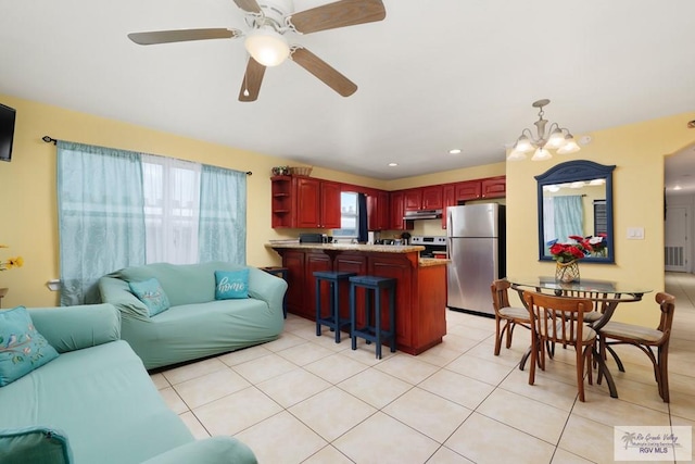 tiled living room featuring ceiling fan with notable chandelier