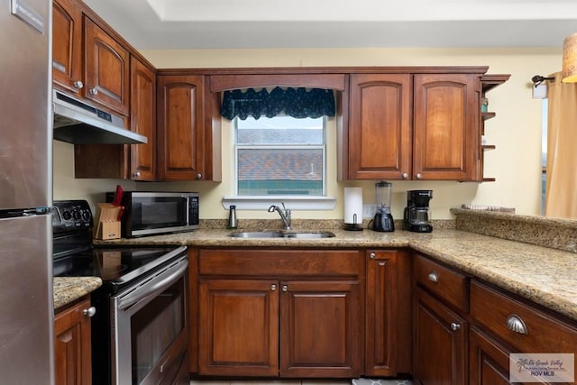 kitchen with stainless steel appliances, light stone counters, and sink