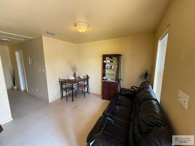 living room with baseboards, visible vents, attic access, and light floors
