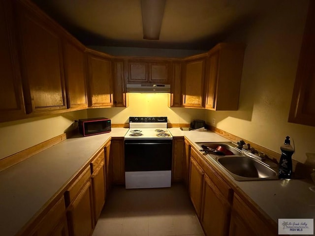 kitchen featuring a sink, light countertops, under cabinet range hood, and electric stove