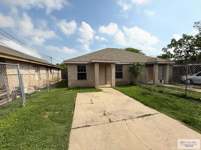 view of front of house with a shingled roof, a front yard, fence private yard, and brick siding