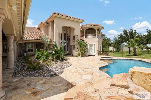 back of property featuring a balcony and a patio