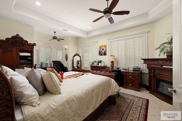 bedroom with ceiling fan and a raised ceiling