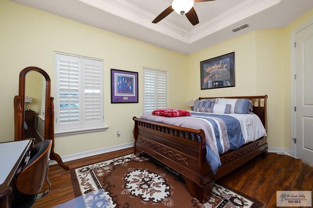 bedroom featuring a raised ceiling, multiple windows, ceiling fan, and dark hardwood / wood-style floors