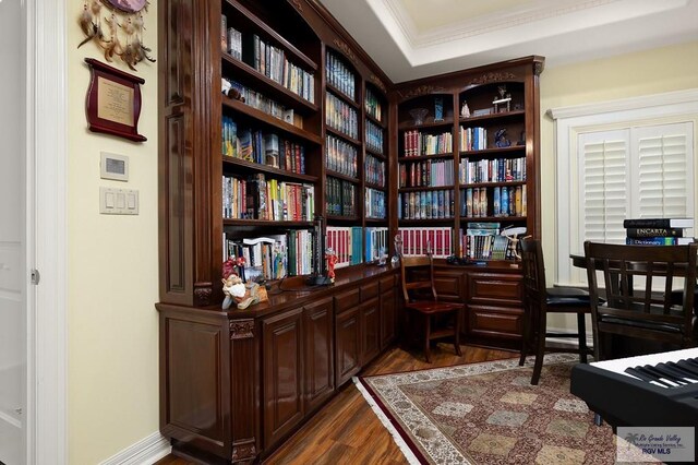 living area with a tray ceiling, crown molding, and dark hardwood / wood-style floors