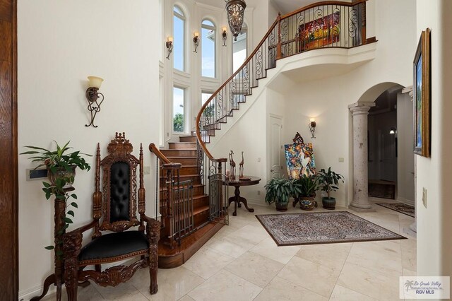 foyer entrance with ornate columns and a high ceiling