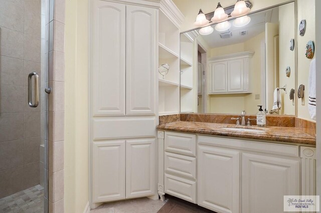 bathroom with vanity and a shower with shower door