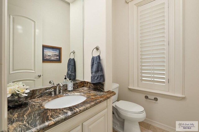 bathroom featuring tile patterned floors, vanity, and toilet