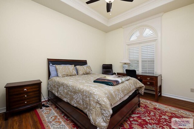 bedroom featuring wood-type flooring, a raised ceiling, ceiling fan, and ornamental molding