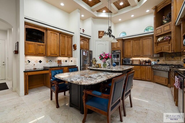 kitchen featuring a center island, a high ceiling, dark stone countertops, tasteful backsplash, and stainless steel appliances