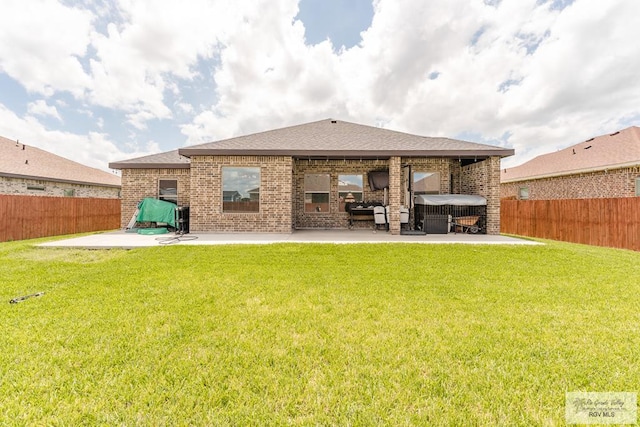 rear view of property featuring a yard and a patio