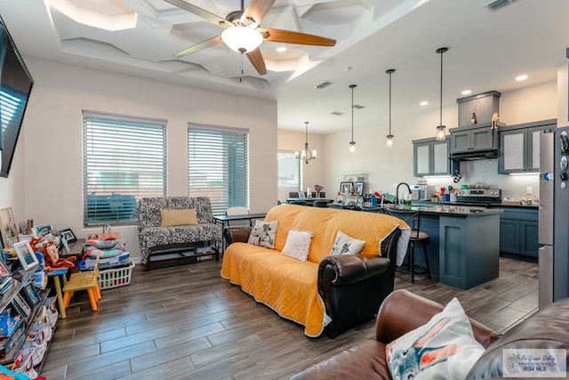 living room featuring a raised ceiling, a healthy amount of sunlight, and dark hardwood / wood-style floors