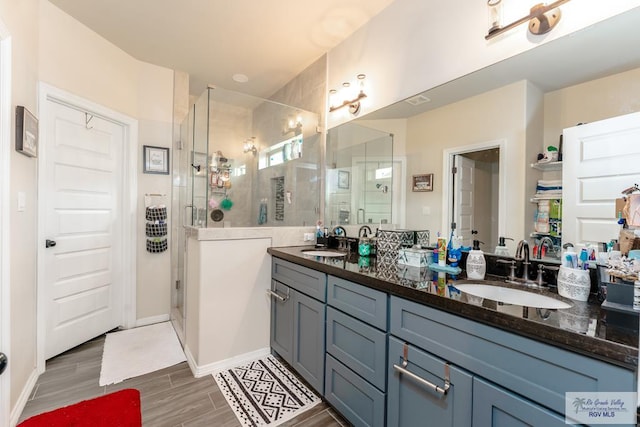 bathroom featuring vanity and a shower with door