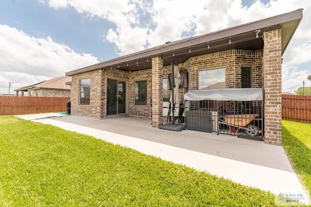 back of property with a patio area and a lawn