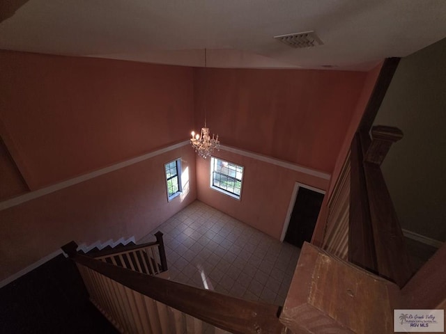 staircase with tile patterned floors, a notable chandelier, and visible vents