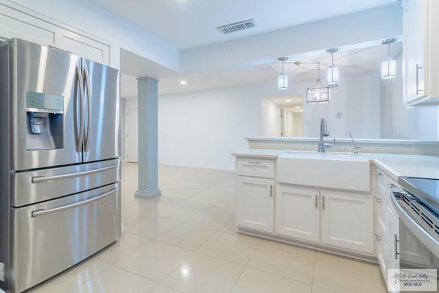 kitchen featuring hanging light fixtures, white cabinets, stainless steel appliances, and sink