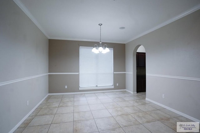 tiled spare room featuring crown molding and a notable chandelier