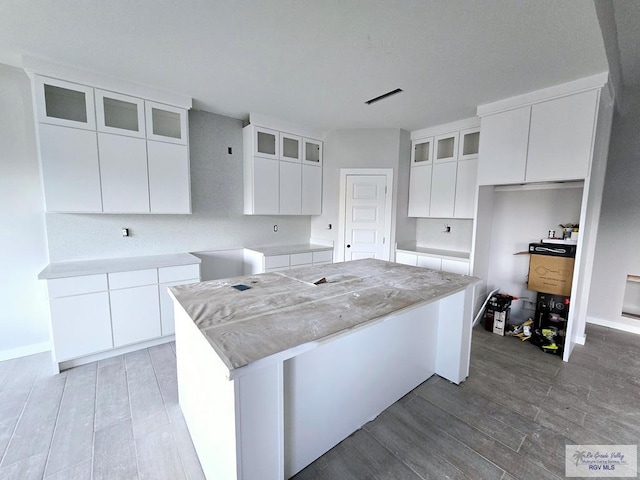 kitchen featuring white cabinetry, light hardwood / wood-style floors, and a center island