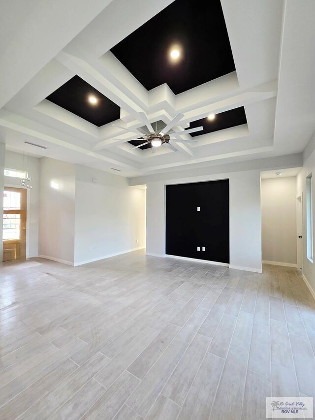105 Republic Cir, San Benito, TX 78586 - unfurnished living room featuring coffered ceiling, a ceiling fan, baseboards, light wood-style flooring, and beamed ceiling