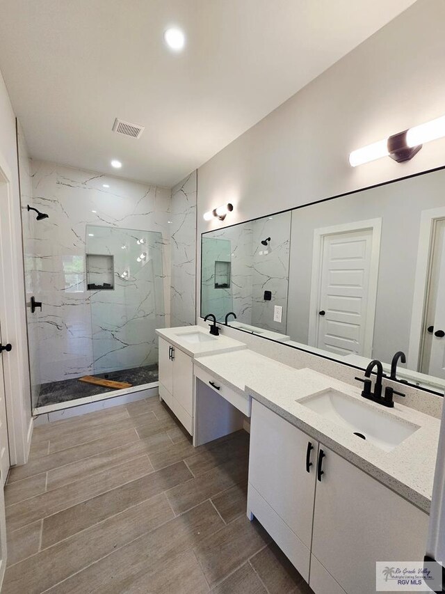 105 Republic Cir, San Benito, TX 78586 - bathroom featuring a marble finish shower, double vanity, wood finished floors, and recessed lighting