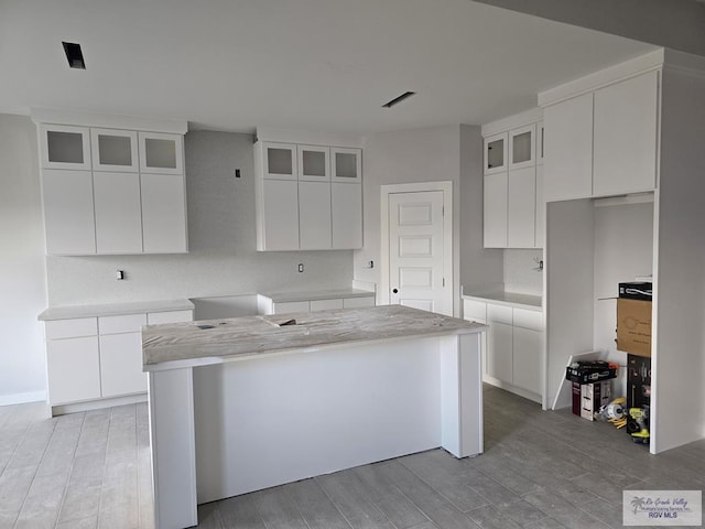 kitchen with tasteful backsplash, a center island, and white cabinets