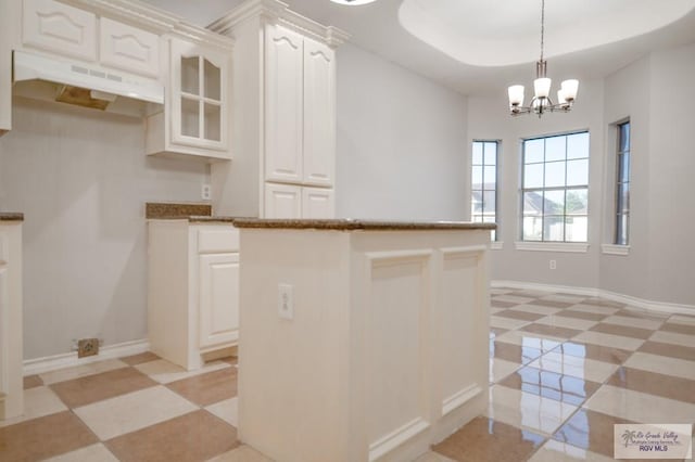 6724 Pino Verde Dr, Brownsville, TX 78526 - kitchen featuring light floors, baseboards, under cabinet range hood, and pendant lighting