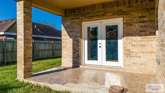 6724 Pino Verde Dr, Brownsville, TX 78526 - doorway to property featuring fence, french doors, brick siding, and a patio