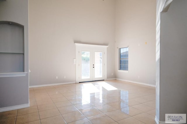 6724 Pino Verde Dr, Brownsville, TX 78526 - unfurnished room with baseboards, a high ceiling, and light tile patterned floors