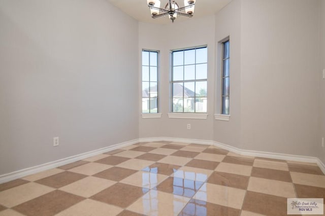 tiled empty room featuring a notable chandelier