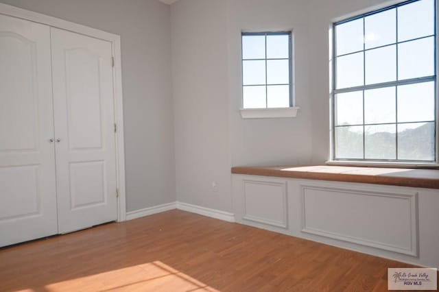 unfurnished bedroom featuring light wood-type flooring and a closet