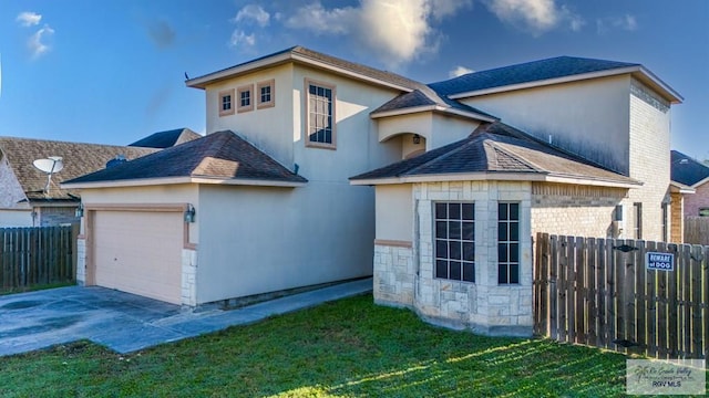 6724 Pino Verde Dr, Brownsville, TX 78526 - view of front of home featuring an attached garage, fence, stone siding, and driveway
