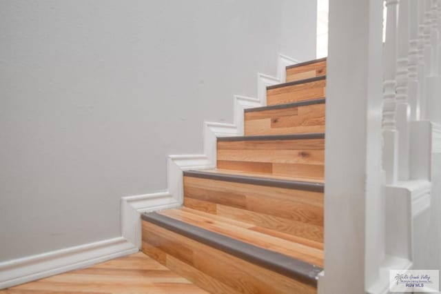 staircase with hardwood / wood-style floors